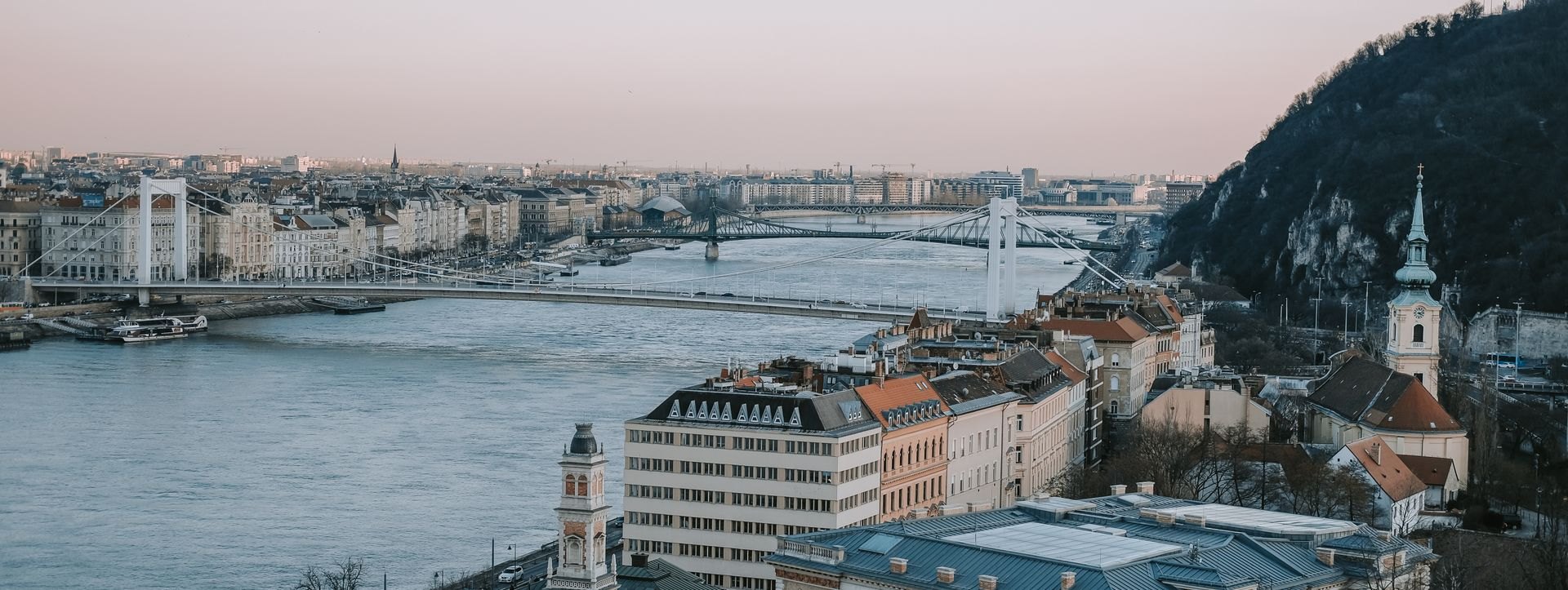 Riverfront buildings and bridges at dusk; illustrative city photograph